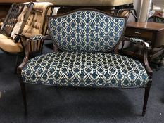 A mahogany framed shield back settee upholstered in brocade