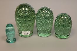 A graduated set of three Victorian glass dumps with bubble inclusions,