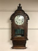 A 19th century mahogany wall clock with mirrored panelled back