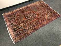 A North West Persian rug on burnt-orange ground,