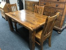 A plantation pine table and three rail back chairs