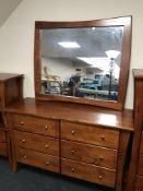 A contemporary stained pine six drawer chest with over mantel mirror
