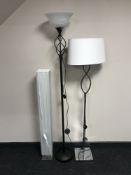 A black uplighter with white glass shade,