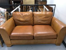 A tan leather two seater settee