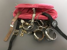 A lady's pink clutch bag containing assorted wrist watches
