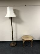 A circular walnut glass topped table together with a standard lamp and shade