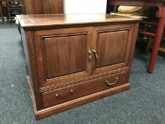 A contemporary hardwood double door low cabinet fitted a drawer