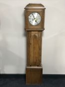 An oak cased granddaughter clock with silvered dial