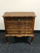 A carved oak three drawer chest
