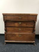 An antique four drawer chest with pillar supports