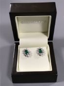A pair of 18ct white gold emerald and diamond cluster earrings