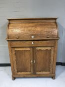 An Edwardian oak roll topped bureau