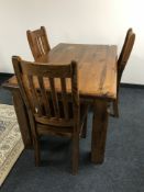 A plantation pine table and three rail back chairs