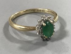 A 9ct gold emerald and diamond cluster ring,