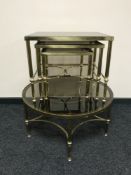 A circular brass glass topped table together with nest of three tables