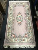 A pink fringed Chinese rug