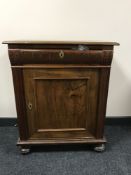 A walnut single door cabinet on bun feet