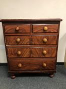 A Victorian stained pine five drawer chest on bun feet,