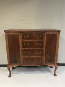A mahogany breakfronted cabinet fitted with four drawers on claw and ball feet