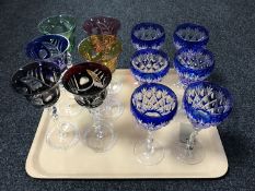 A tray of two sets of six coloured crystal wine glasses
