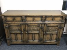 A Georgian style oak triple door sideboard