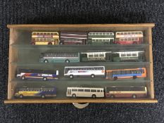 A small display case containing thirteen die cast buses and trams