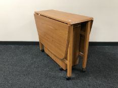 A teak drop leaf storage table