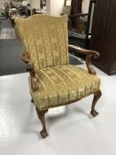 A carved walnut framed armchair in gold fabric