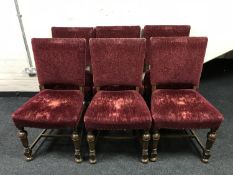 A set of eight oak dining chairs upholstered in maroon fabric
