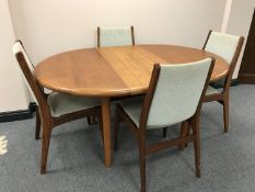 A circular Danish teak extending dining table with fitted leaf and four chairs