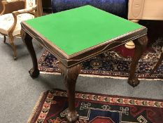A mahogany baize topped card table on claw and ball feet