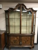 A Georgian style mahogany display cabinet with arched top above double cupboards below,