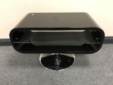 A contemporary black gloss television stand, on a circular chrome base.