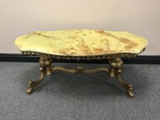A shaped onyx coffee table on a gilt metal base