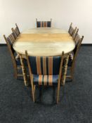 A blond oak circular extending dining table with leaf,