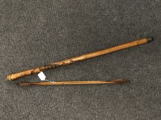 An African walking cane together with a pair of wooden shaft arrows bearing the name Honorable Ble