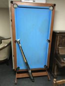 A folding BCE pool table with cues and balls fitted with a dart board