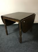 A late 20th century oak drop leaf table with extension leaf