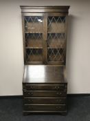 An early 20th century oak bureau bookcase with leaded glass doors