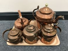 A tray containing five vintage copper kettles