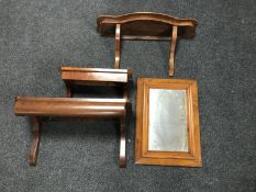 A mahogany framed wall mirror and three wall shelves