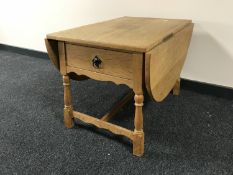 A blond oak drop leaf coffee table fitted a drawer