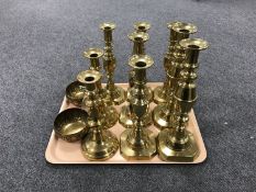 A tray of four pairs of brass candlesticks, one candlestick,