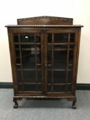 A mahogany double door display cabinet on claw and ball feet