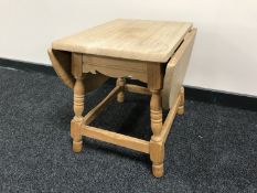 A blond oak drop leaf coffee table
