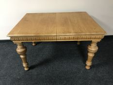 An antique oak extending table on turned legs with five pine extension leaves