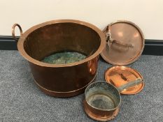 A large copper twin-handled cooking pot together with a copper saucepan and four lids