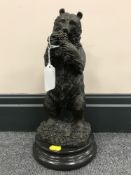 A bronze figure of a bear standing on hind legs, on plinth.
