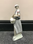 A Lladro figure of a lady carrying a cockerel,