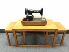 A teak table fitted two beneath together with a Singer electric sewing machine
